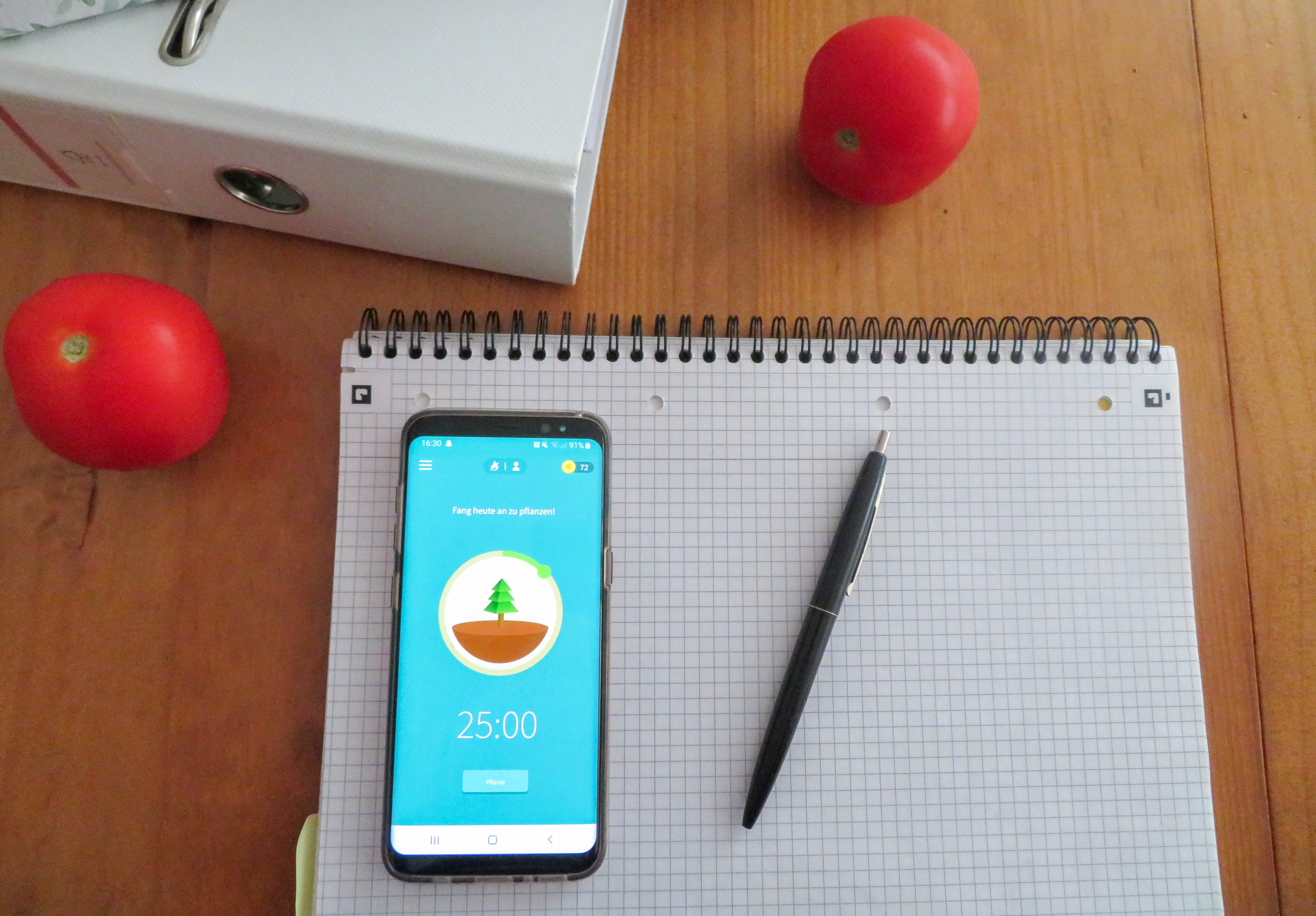 Selbsttest_Motivationstipps_Pomodoro&Forest-2 Smartphone liegt auf einem Notizblock