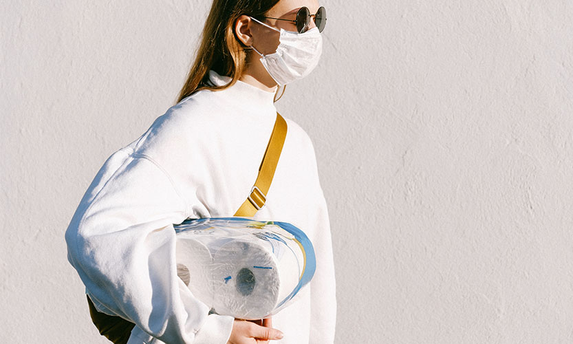Frau mit Maske und Klopapier