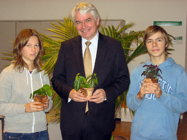 Lehrlinge des botanischen Gartens übereichen Rektor Heinrich Schmidinger selbstgezogene Büropflanzen