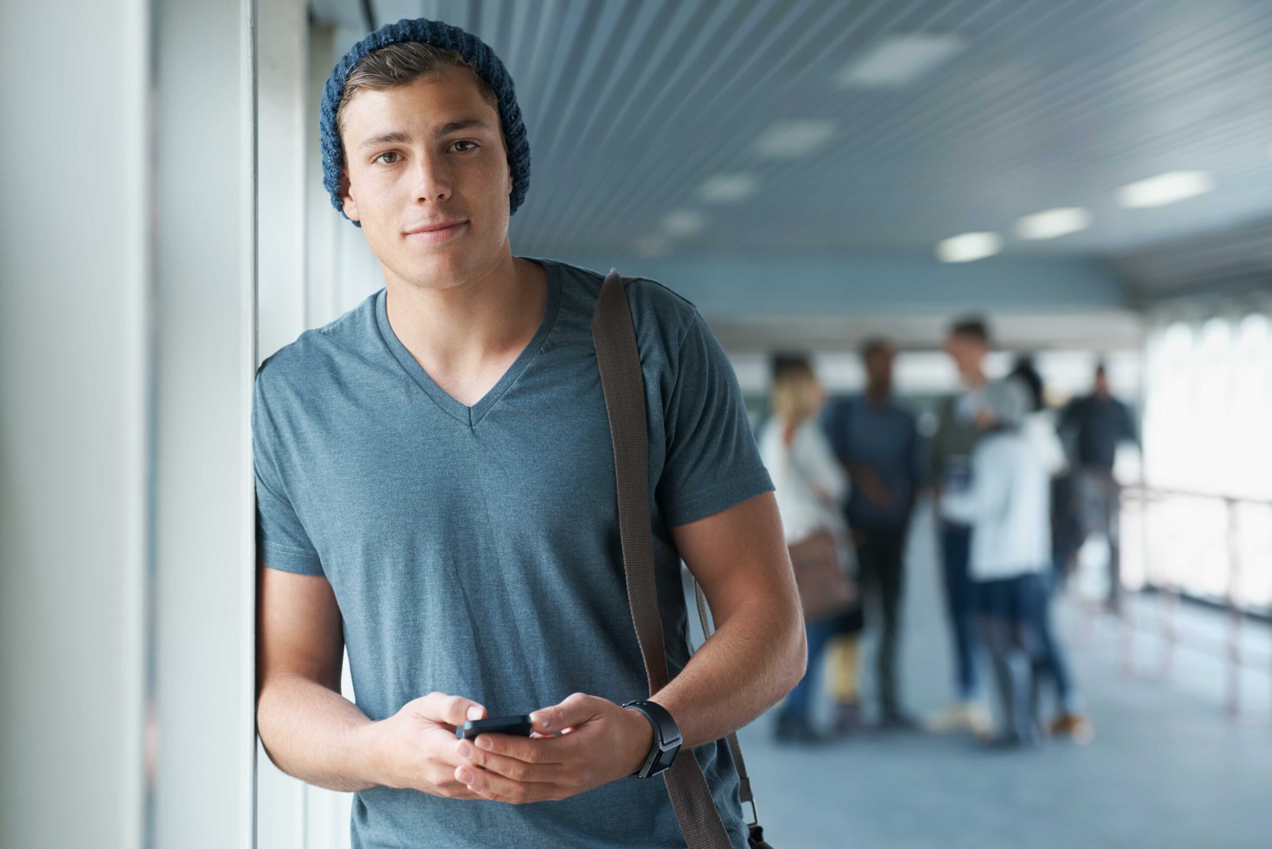 A young college student sending a text message from his smartphone