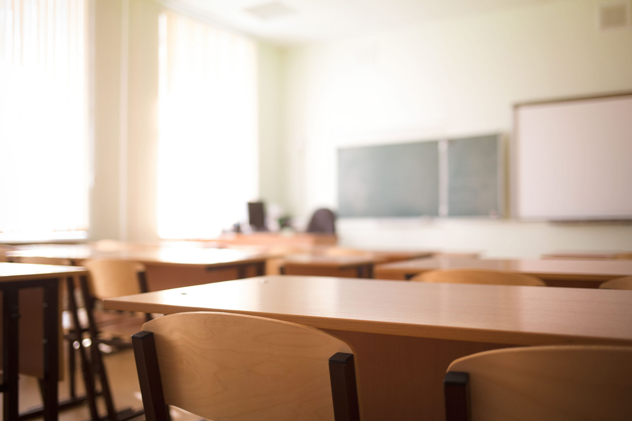 School classroom in blur background without young student; Blurry view of class room no kid or teacher with chairs and tables in campus.