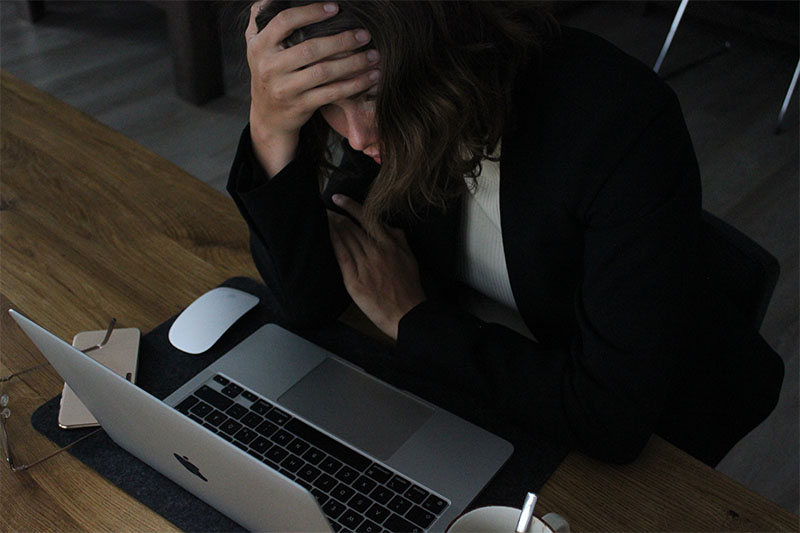 Frau sitzt verzweifelt vorm Laptop