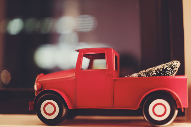 kleines rote Auto vor Christbaum