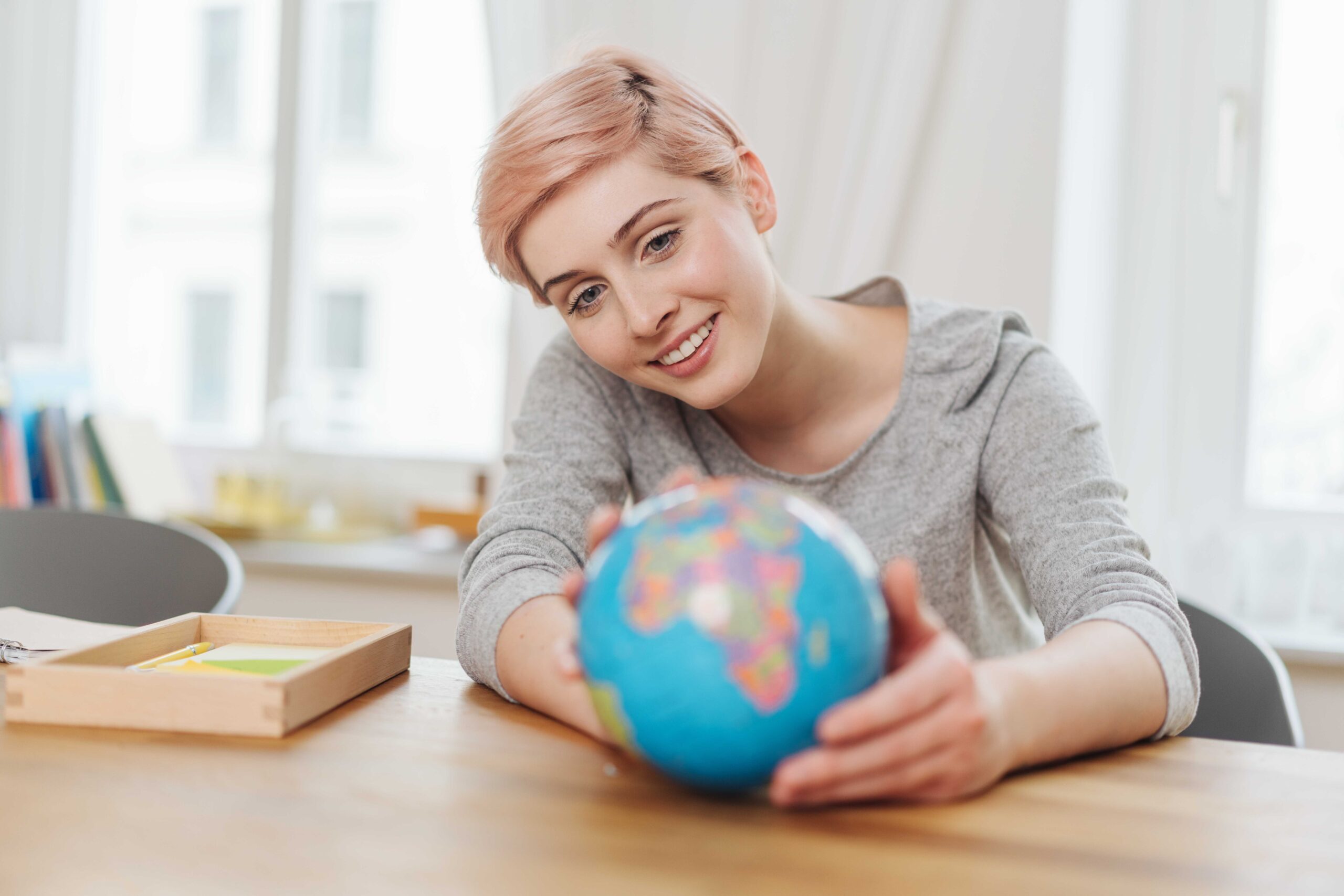Young woman holding a world globe in her hands