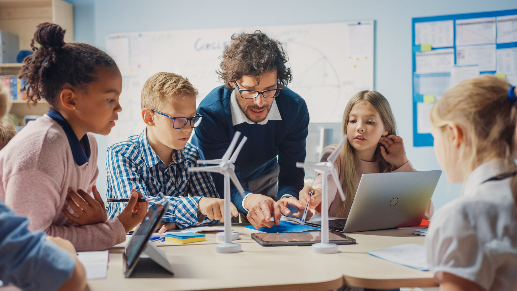 Lehrer mit Schülern und digitalen Medien