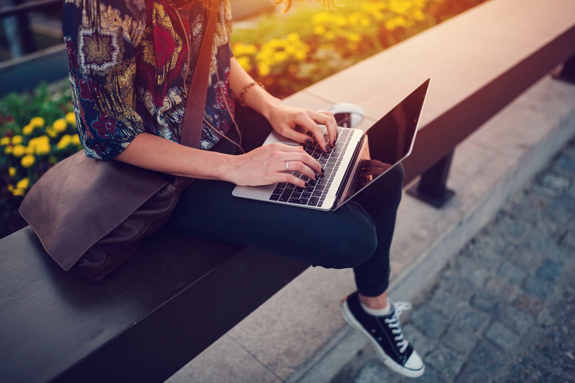 Teenage girl using lap top at the bridge