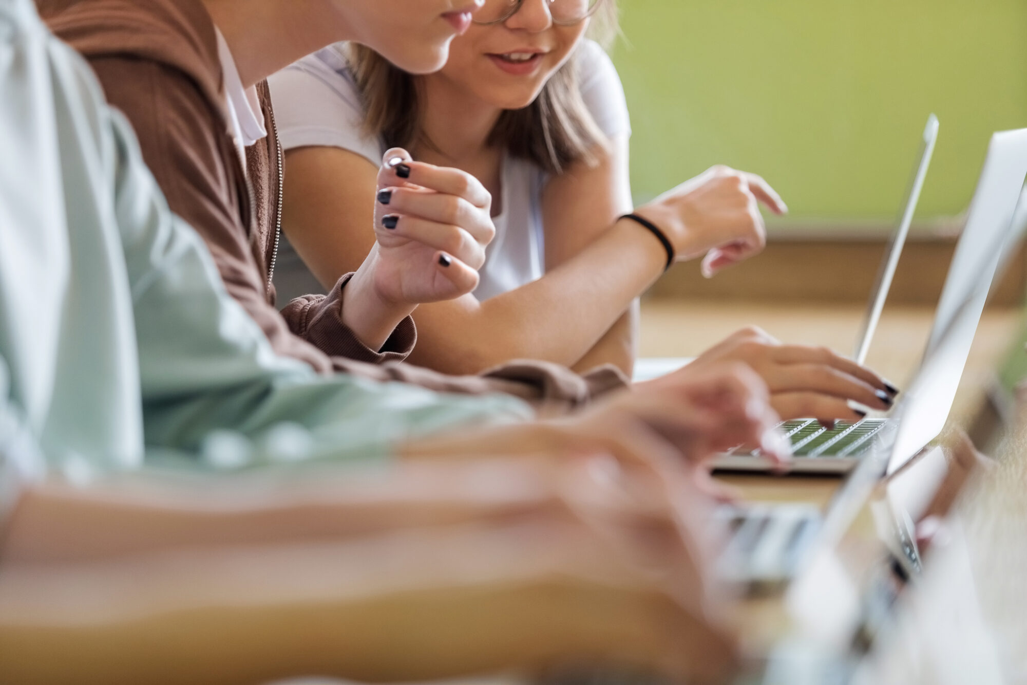 Teenage girls using laptops in the classroom