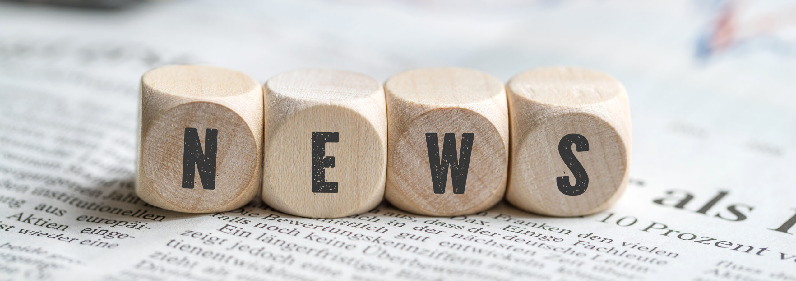 Würfel mit dem Wort "NEWS" auf einer Zeitung