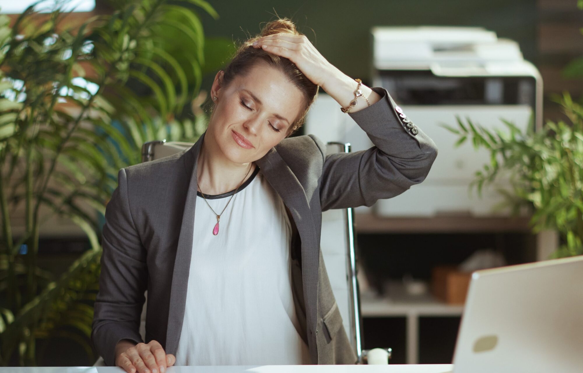 Frau dehnt sich am Arbeitsplatz