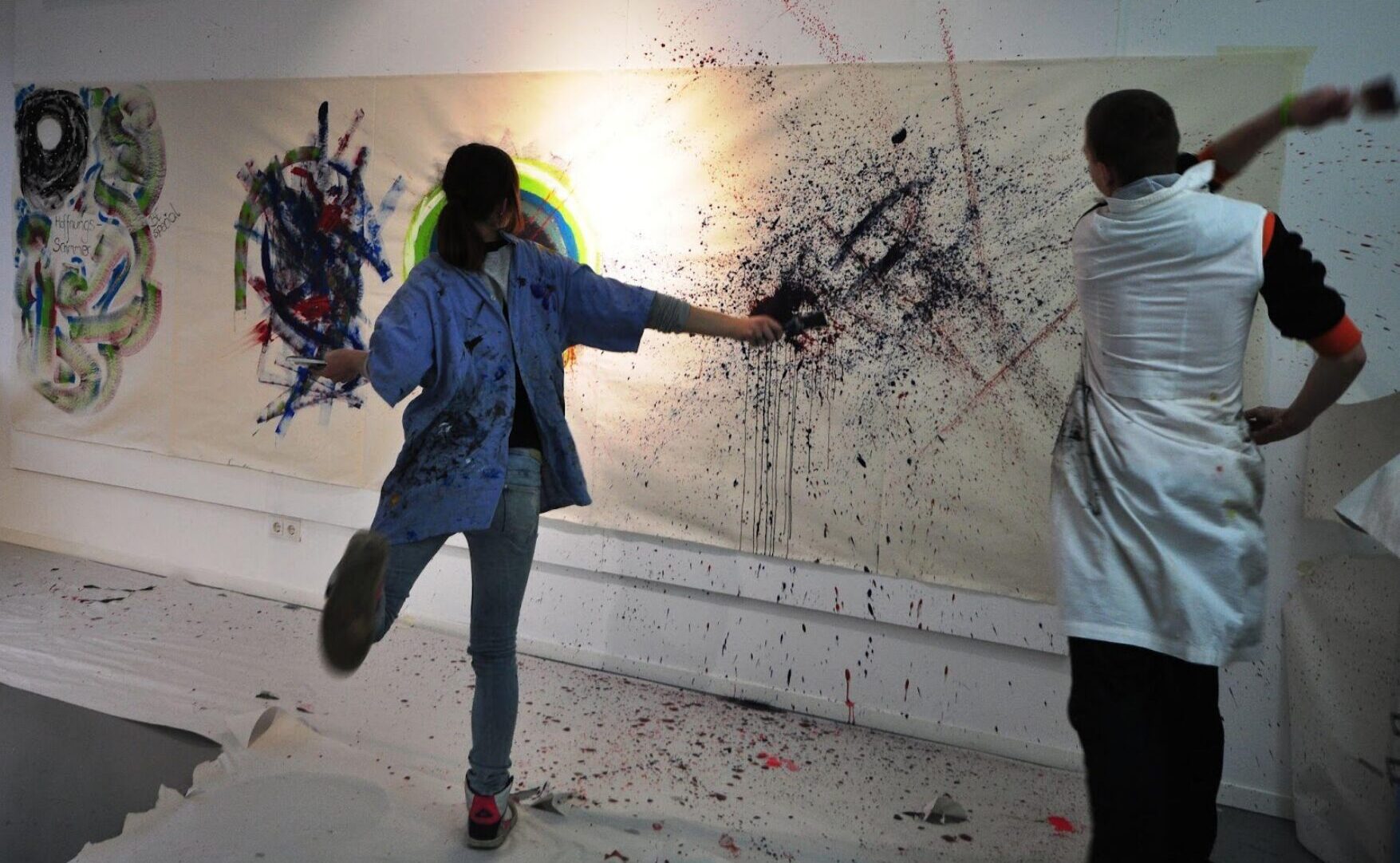 Frauen machen Kunst und spritzen Farbe auf eine Leinwand