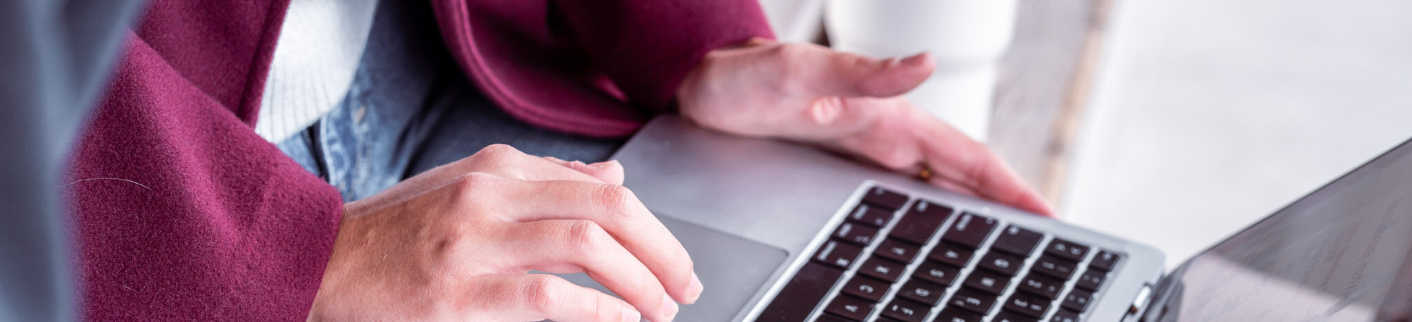 Nahaufnahme von H&auml;nden zweier Personen an einem Laptop