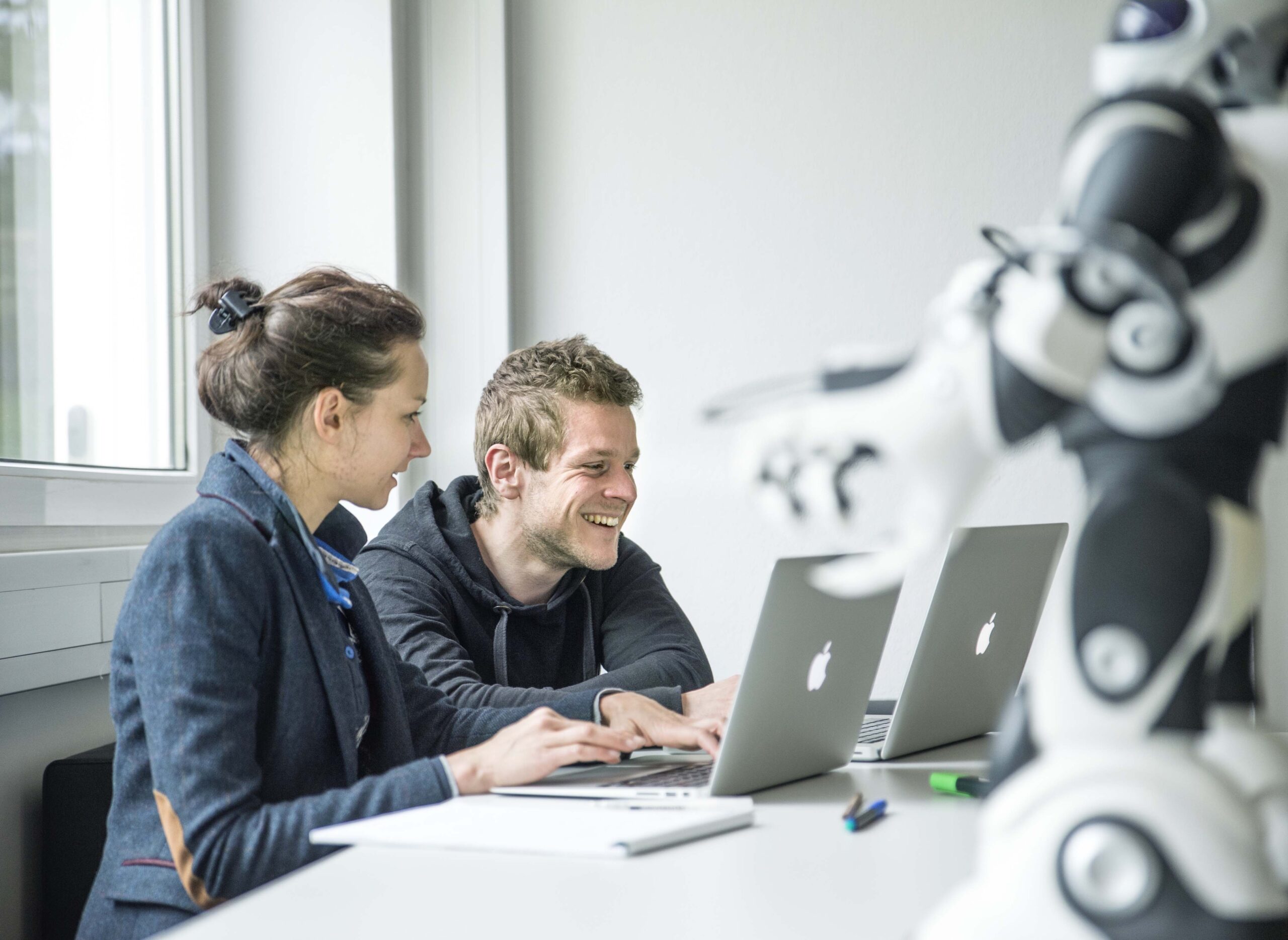 lachende Menschen vor Laptop