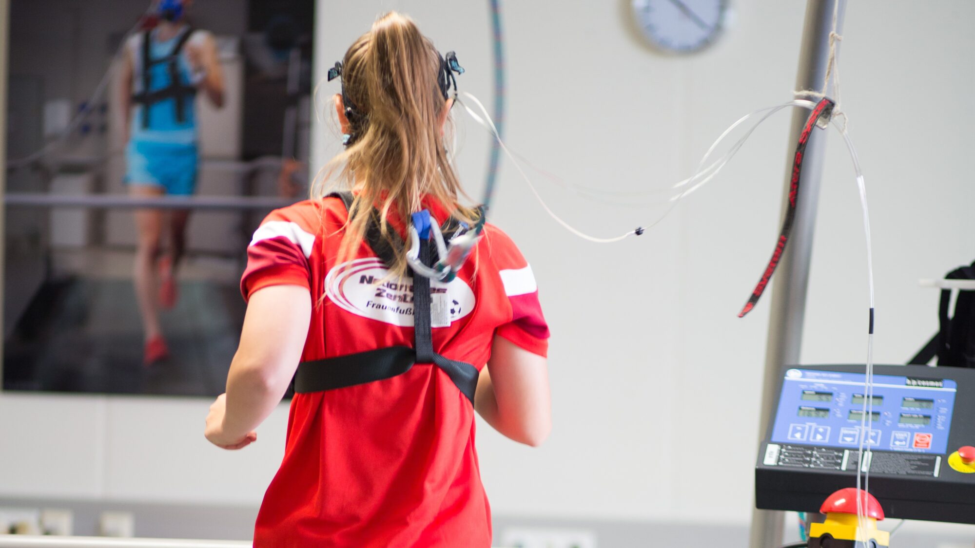 Rückenansicht einer Sportlerin bei Atemtest im Labor