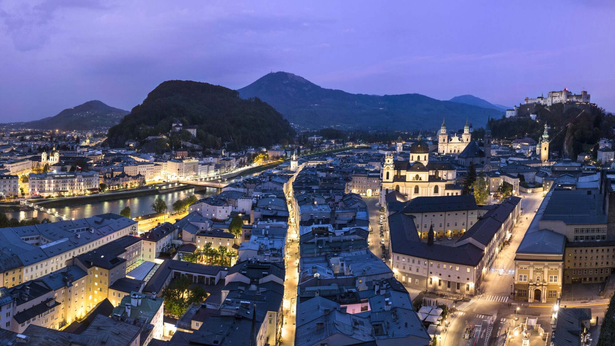 Blick auf die beleuchtete Stadt Salzburg bei Nacht