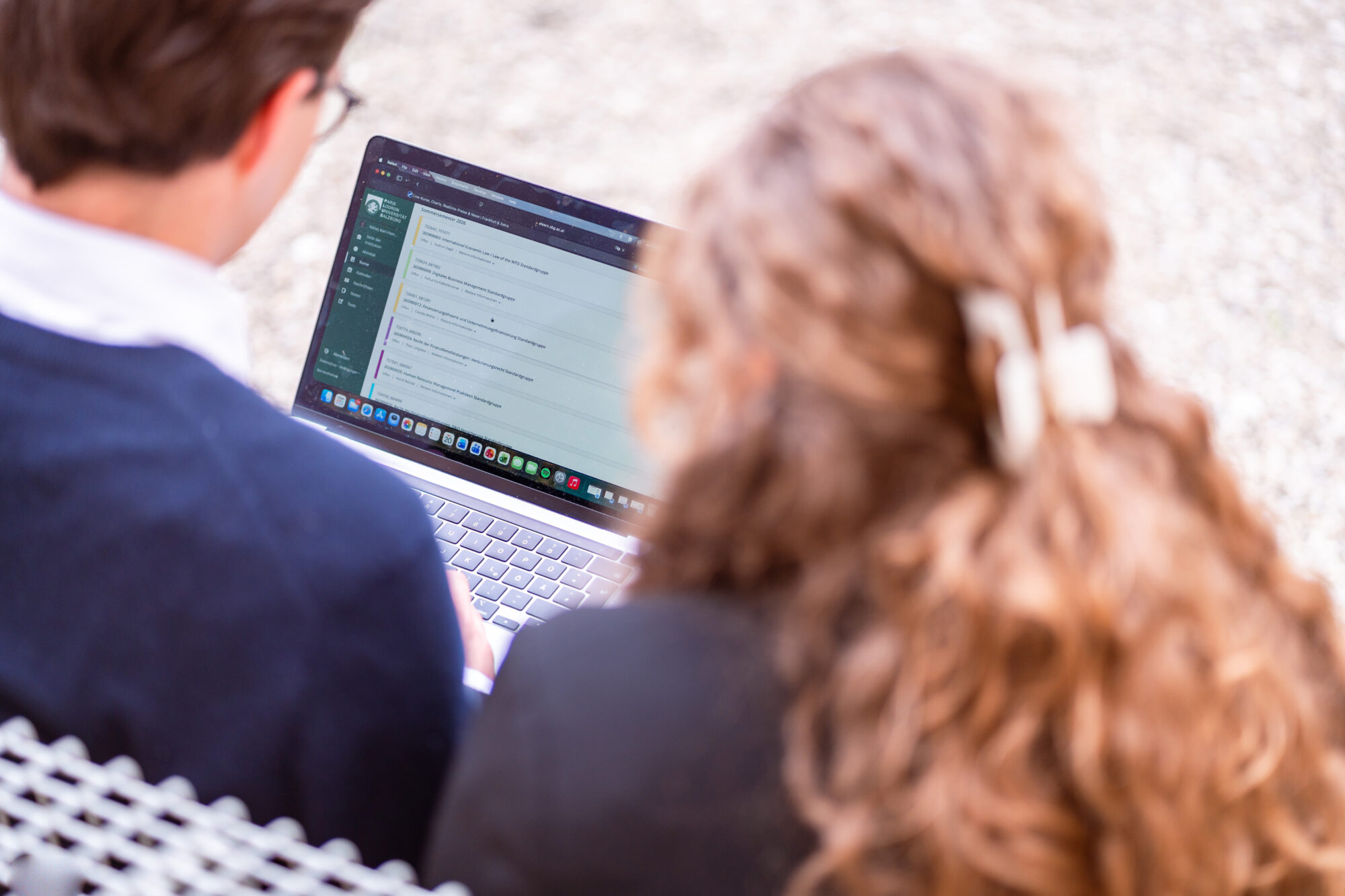 Studierende schauen gemeinsam in Laptop