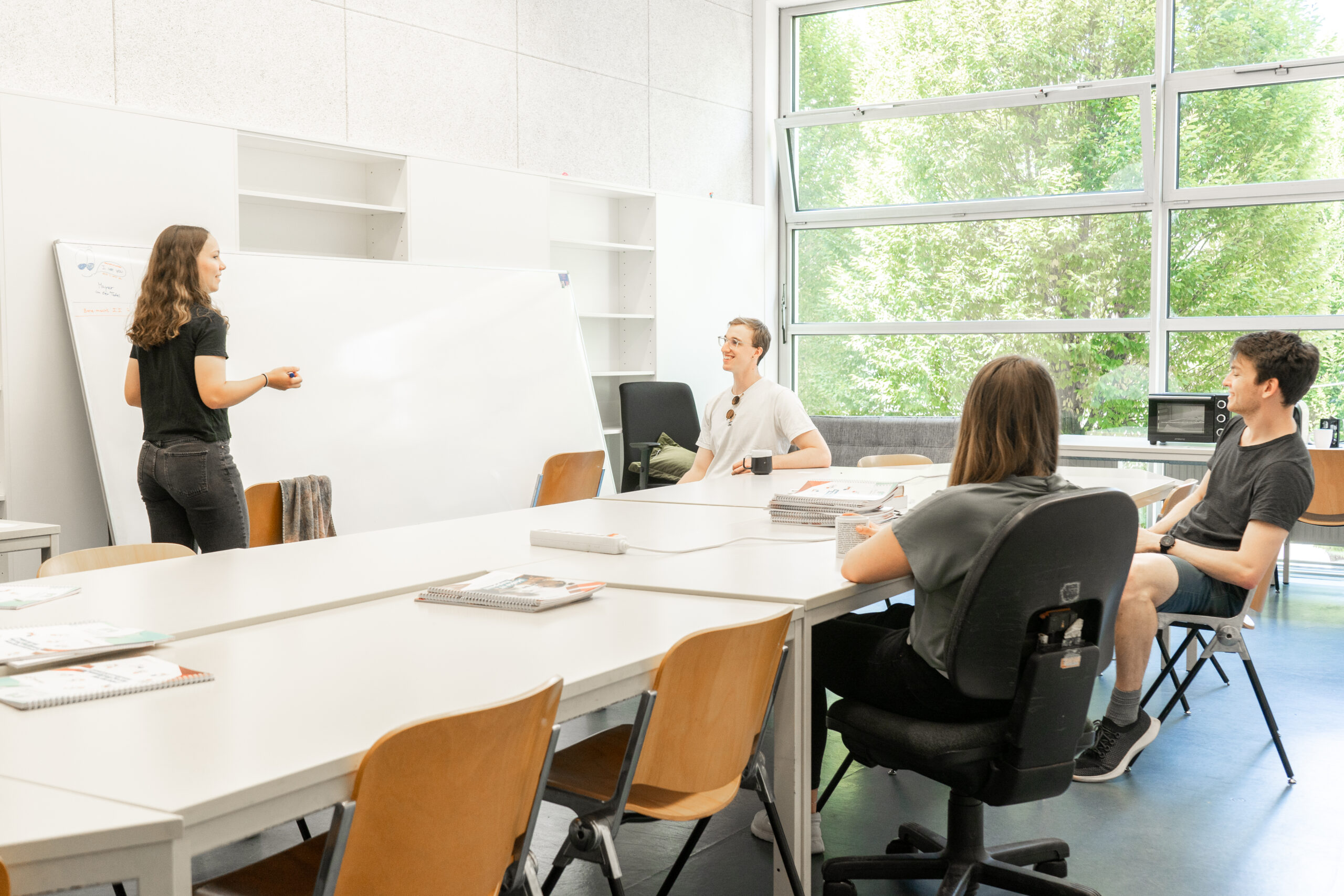 Studierende lernen und diskutieren zusammen in einem Lernraum in Itzling
