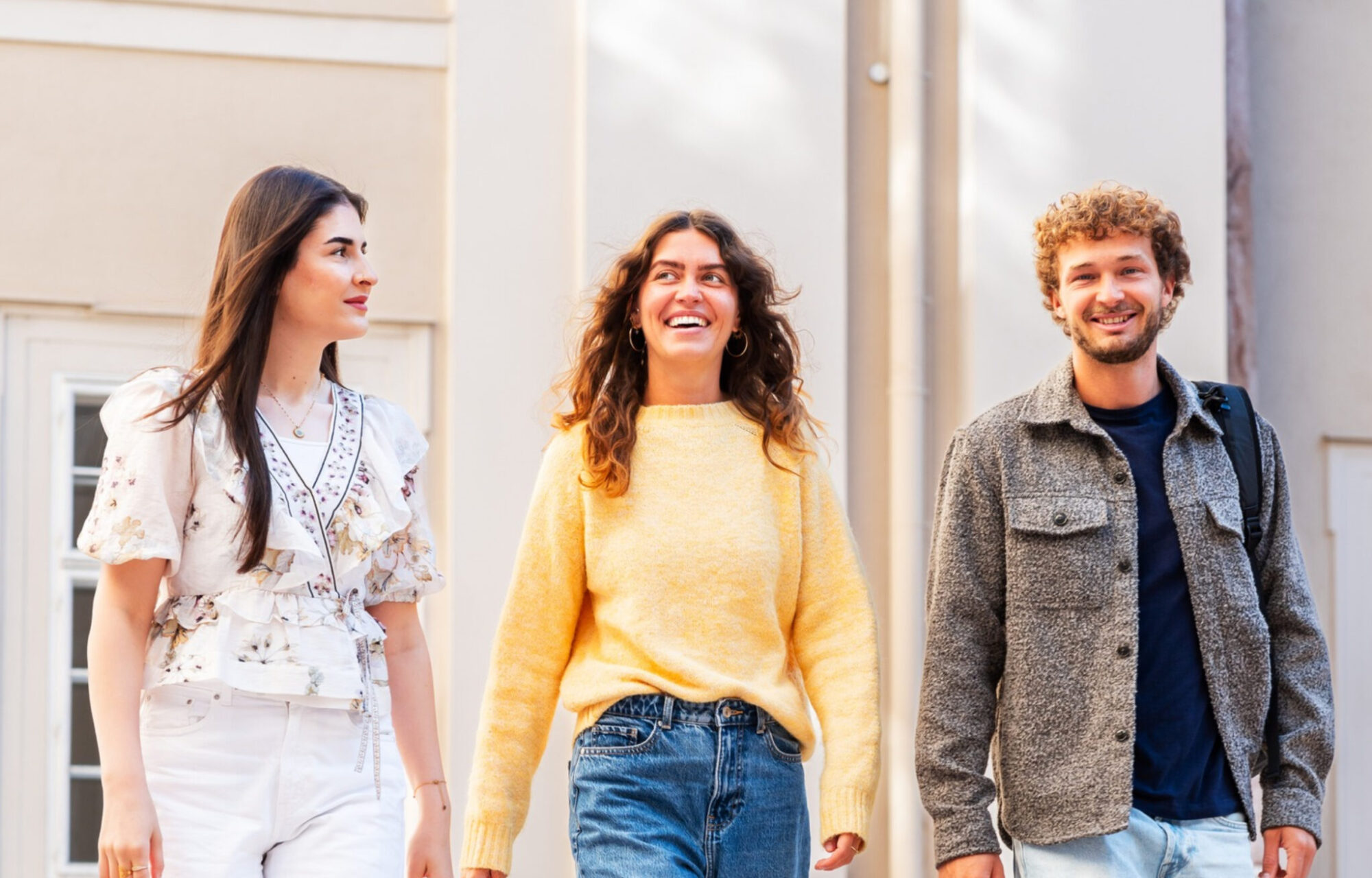 Drei Studierende gehen nebeneinander her