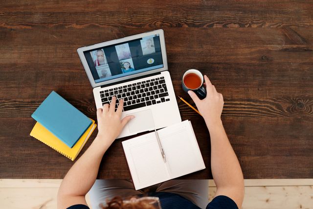 Mit Teetaste, Notizzettel und Kalender in einem Online-Meeting